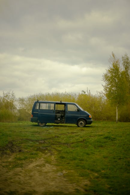 Four vintage Volkswagen camper vans parked closely side by side on a paved surface, with the front of each vehicle visible. The vans are painted in pastel shades of yellow and light green, featuring characteristic rounded shapes and small rectangular windows on the sides. The rear doors are closed, revealing some external details such as the taillights, license plates, and ventilation grills. The setting appears to be outdoors, possibly at a vehicle gathering or event related to house removals and logistics, as part of a moving or transport process. The lighting suggests daytime with natural light illuminating the vehicles, and the focus is on the classic camper vans suitable for home relocation or furniture transport needs. The image aligns with the theme of moving services by showcasing vintage vehicles that could be used for moving or moving equipment, reflecting the company's expertise in removals.